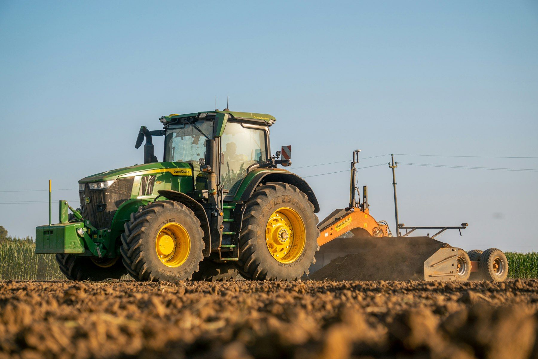 Green tractor ploughing a field